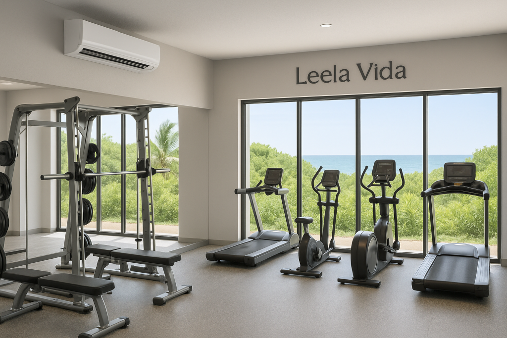 Interior of The Leela Vida Oceanfront Gym with AC unit, vegetation outside the windows, and ocean in the distance.